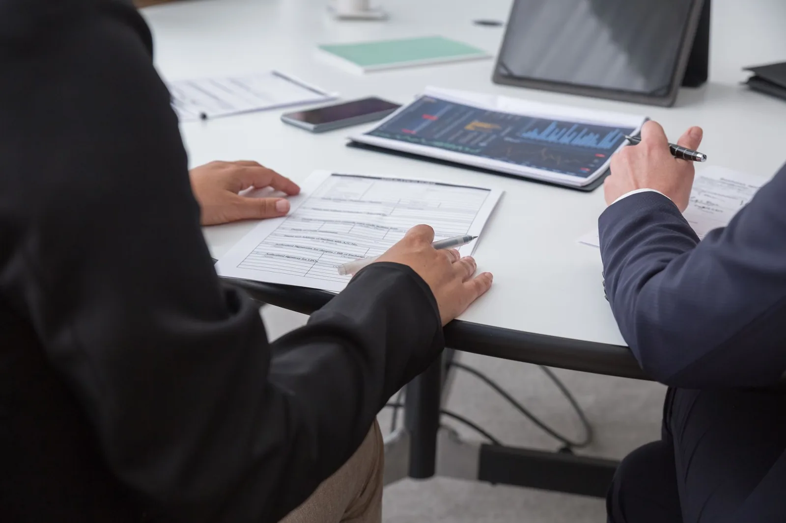Colleagues reviewing printed documents across a meeting table