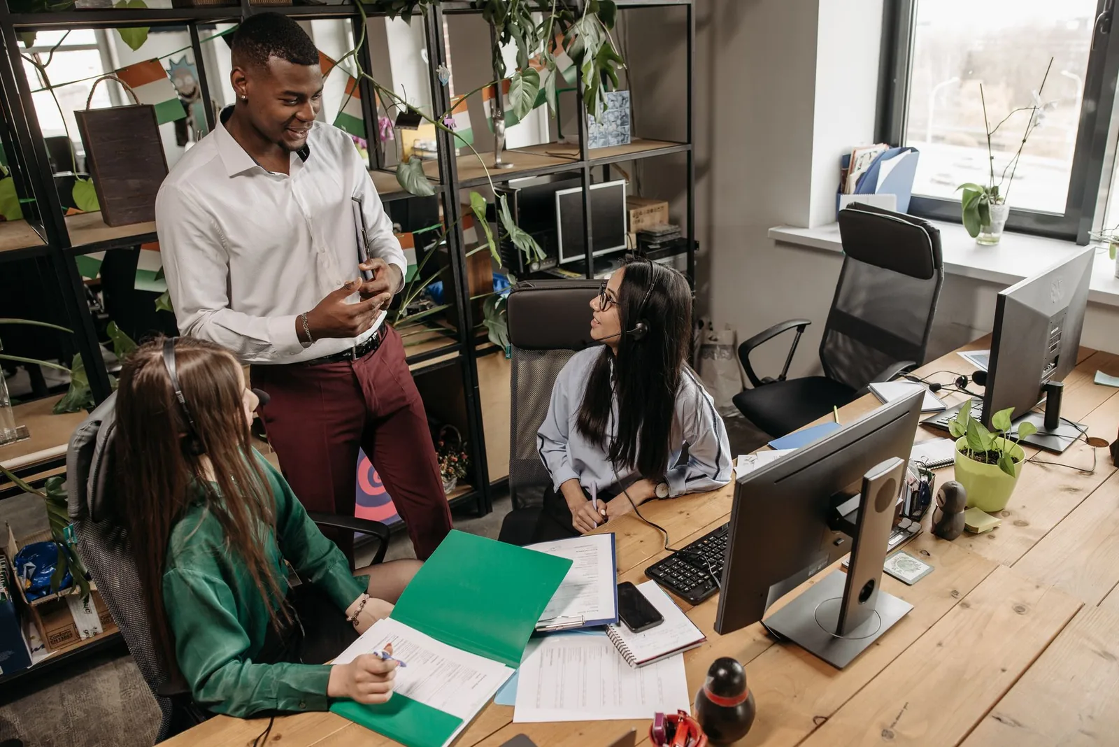An operations team working together at shared desks in a bright office